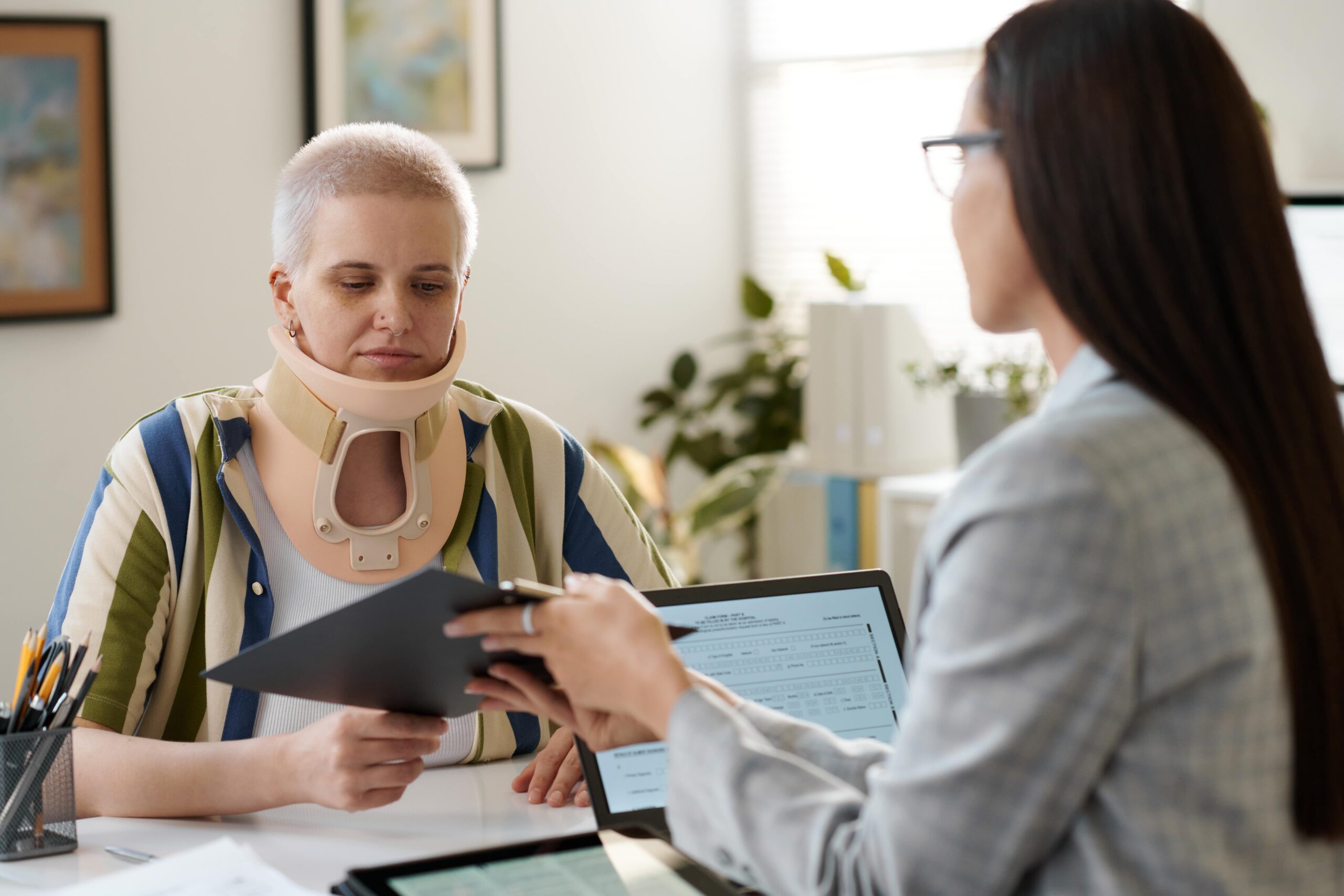 Woman with an injury examining a contract, highlighting concerns about personal injury claims